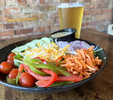 House salad with bell peppers, carrots, shredded cheese, onions and cucumbers.